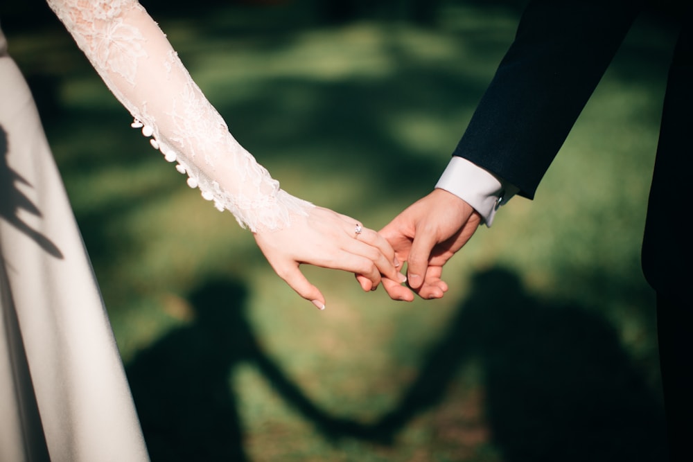 Wedding couple holding hands outdoors